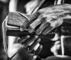 Black and white photo of hand holding bible Stock Photo