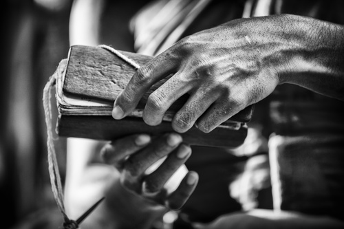 Black and white photo of hand holding bible Stock Photo