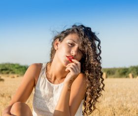 Carefree girl sitting in wheat field Stock Photo