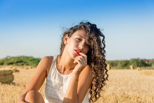 Carefree girl sitting in wheat field Stock Photo