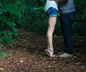 Couple kissing on tiptoe in the woods Stock Photo