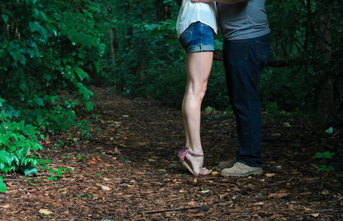 Couple kissing on tiptoe in the woods Stock Photo