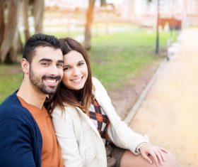 Couple sitting on a park bench Stock Photo