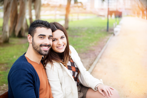 Couple sitting on a park bench Stock Photo