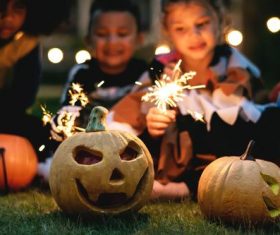 Halloween pumpkins and children putting fireworks Stock Photo
