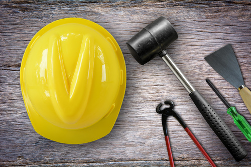 Hard hat and tools on the table Stock Photo