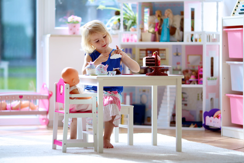 Little girl playing mini doll house at home Stock Photo 01