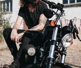 Long-haired man sitting on motorcycle Stock Photo