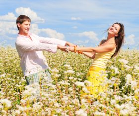 Lovers hand in hand in the flowers Stock Photo