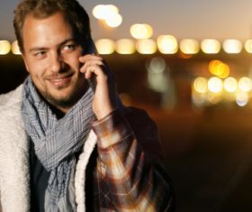 Man answering the phone and blurred lights behind him Stock Photo