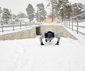 Man doing push-ups on the snow Stock Photo