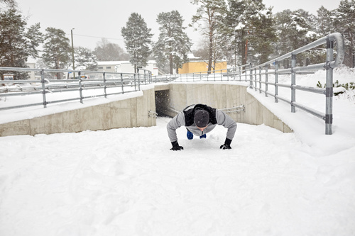 Man doing push-ups on the snow Stock Photo