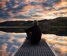 Man sitting by lake Stock Photo