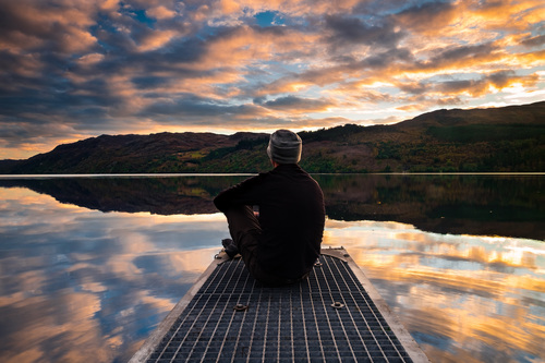 Man sitting by lake Stock Photo