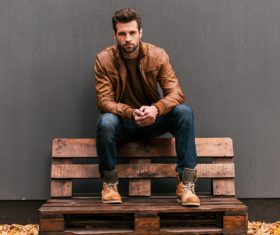 Man sitting on wooden sofa Stock Photo
