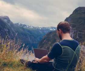 Man using laptop outdoors Stock Photo