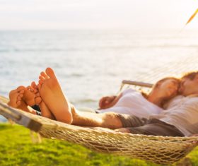 Men and women lying together in hammock Stock Photo