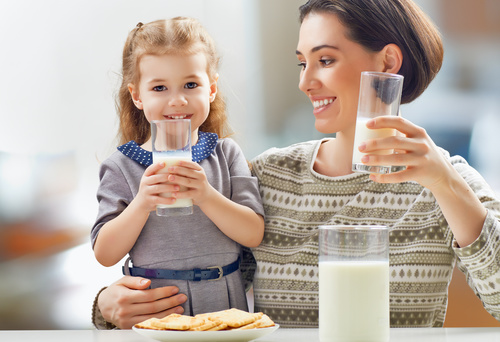 Mother and daughter drinking milk together Stock Photo