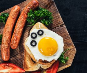 Omelette and fried sausage on cutting board Stock Photo