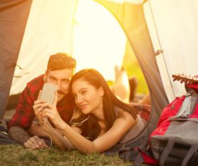 Self-portrait with mobile phone in camping tent Stock Photo