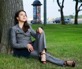 Stock Photo Businesswoman sitting relaxed on the grass