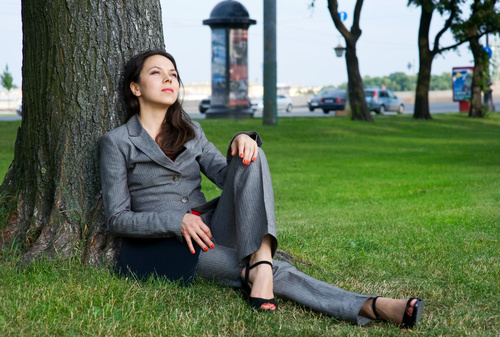 Stock Photo Businesswoman sitting relaxed on the grass