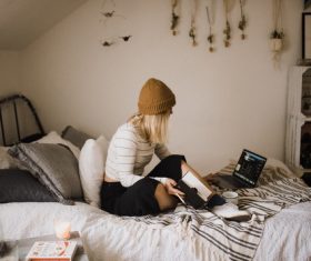 Stock Photo Girl sitting in bed studying