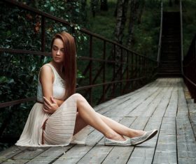 Stock Photo Girl sitting on the bridge