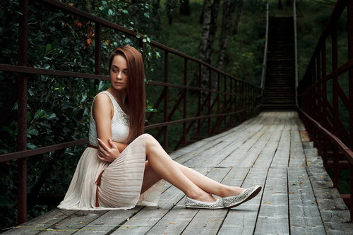 Stock Photo Girl sitting on the bridge