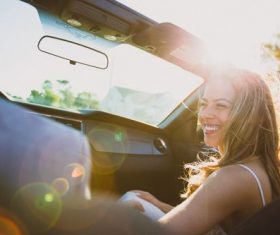 Stock Photo Happy woman sitting in the car