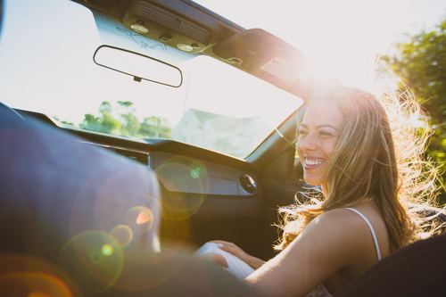 Stock Photo Happy woman sitting in the car