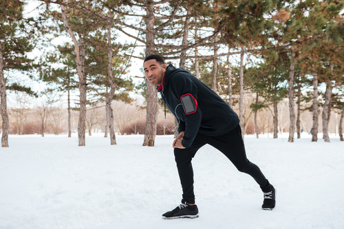 Stock Photo Man doing warm-up exercises on the snow