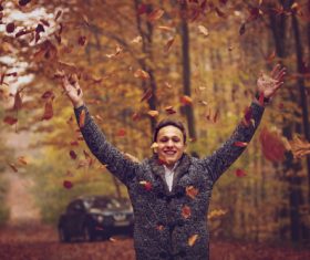 Stock Photo Man throwing fallen leaves in autumn 02