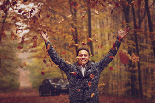 Stock Photo Man throwing fallen leaves in autumn 02