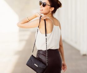 Street shot of woman with sunglasses holding satchel Stock Photo
