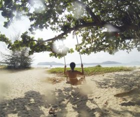 Swing woman playing on the beach by the sea Stock Photo