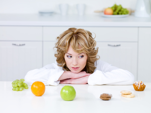Woman choosing what to eat Stock Photo