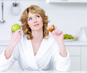 Woman holding apple and cake Stock Photo