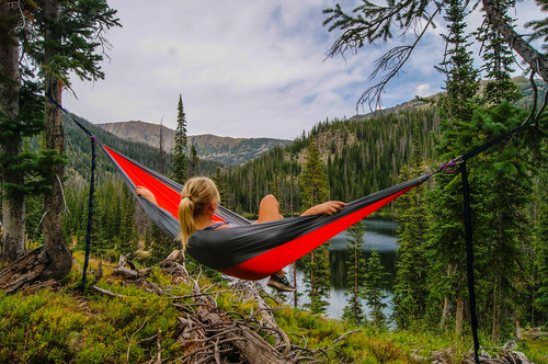 Woman sitting in hammock admiring the natural scenery Stock Photo