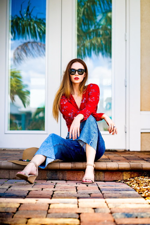 Woman sitting in the door wearing sunglasses Stock Photo