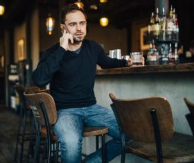 Young man drinking make phone call at the bar Stock Photo