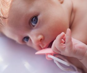 Baby holding a pacifier Stock Photo