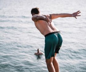 Back barefoot man jumped into the sea Stock Photo