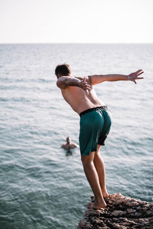 Back barefoot man jumped into the sea Stock Photo