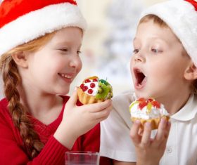 Child wearing christmas hat eating cake Stock Photo 02