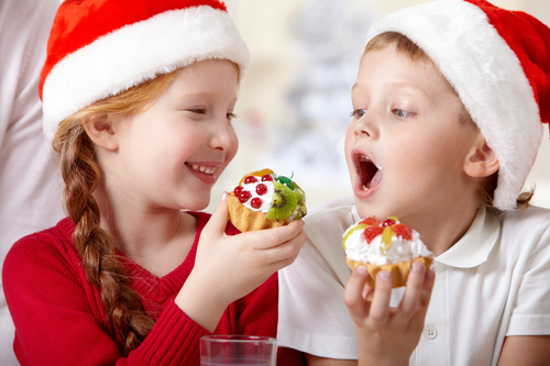 Child wearing christmas hat eating cake Stock Photo 02
