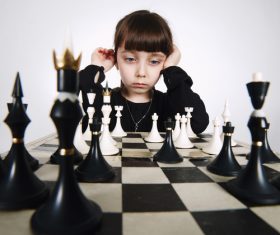 Little girl concentrates on playing Chess Stock Photo