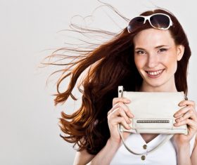 Smiling woman holding handbag Stock Photo
