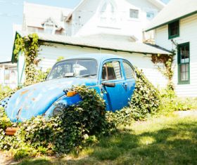 Stock Photo Abandoned car behind the house