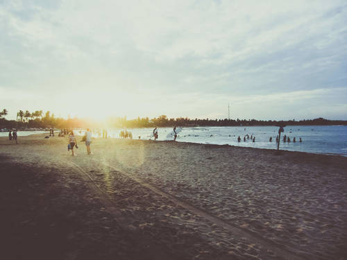 Stock Photo Backlit shot of people playing on the beach